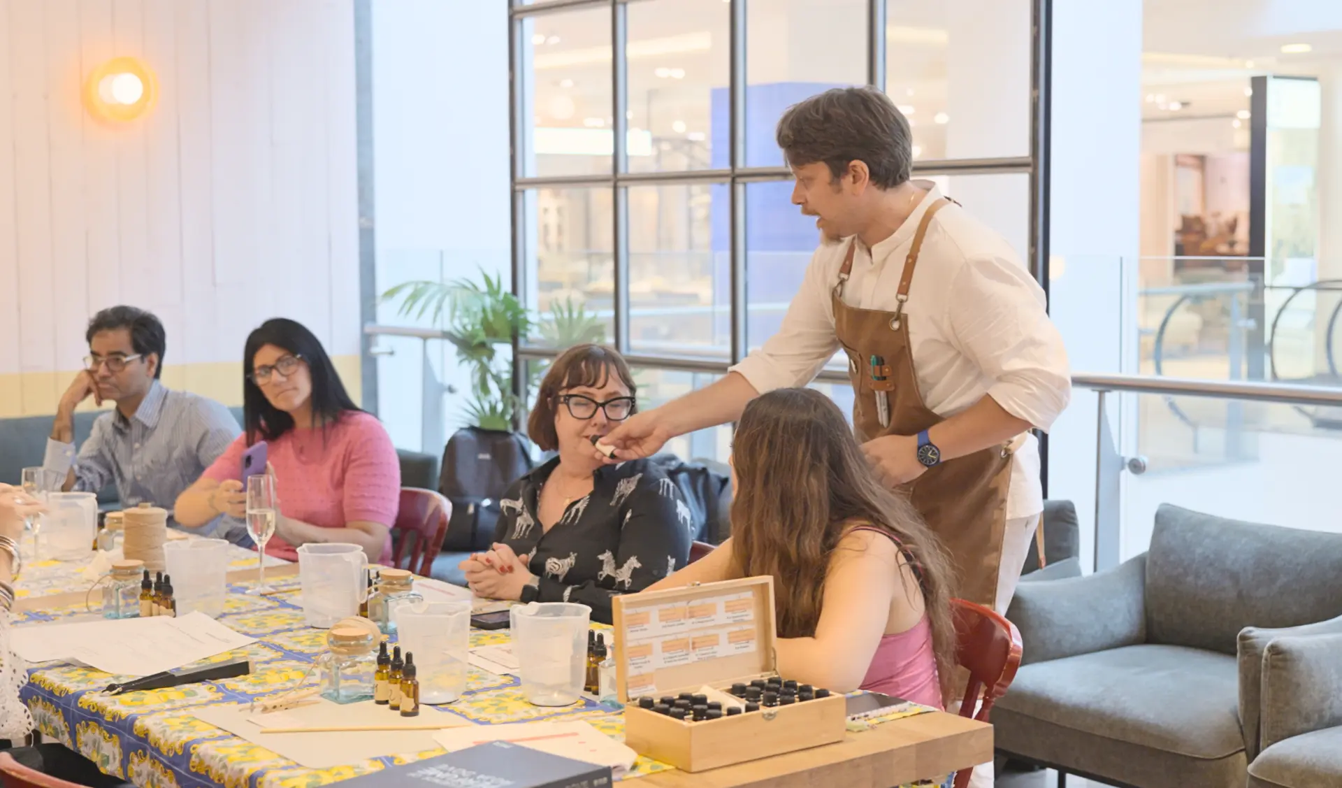 The workshop group seated around the table with fragrance samples, jars and glasses